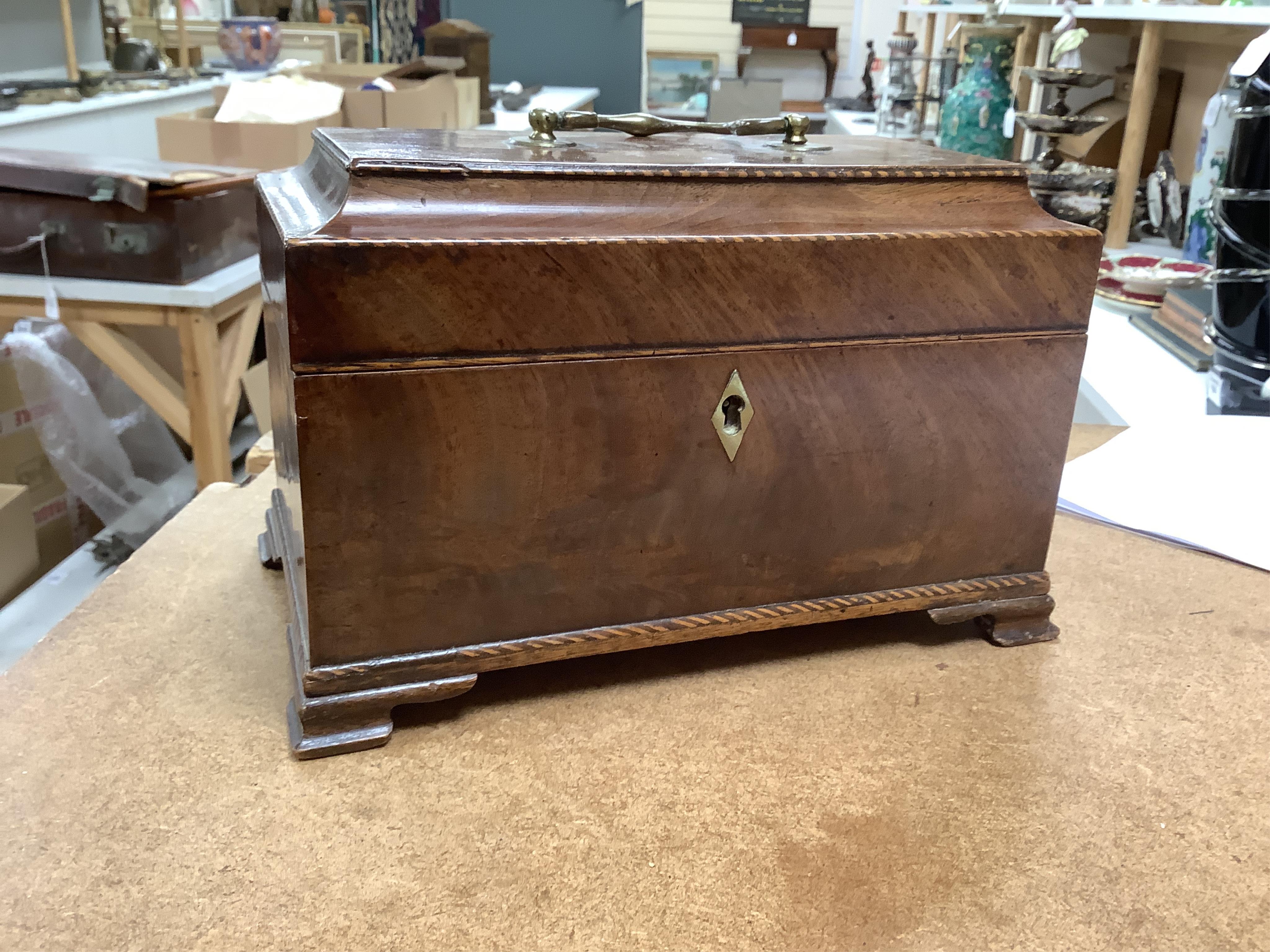 A George III mahogany tea caddy, containing tinned metal canisters, 25cm wide